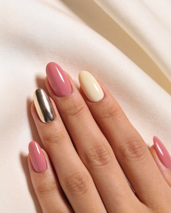 Glossy pink and cream almond nails with a chrome accent nail on pale silk