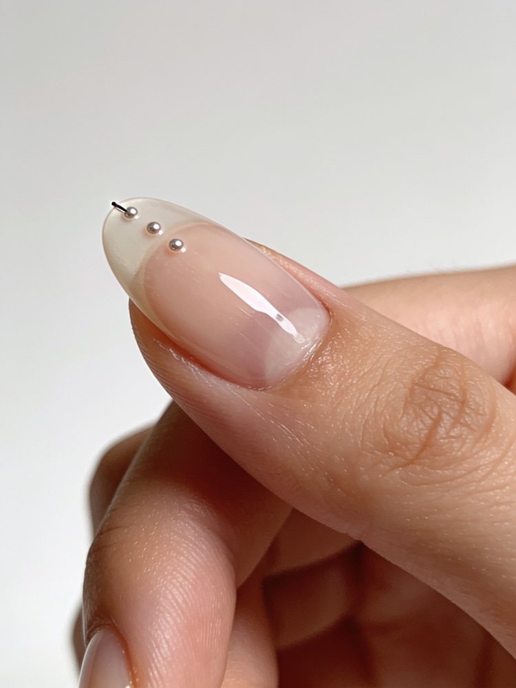 Short round nails with tiny scattered white dots near the tips
