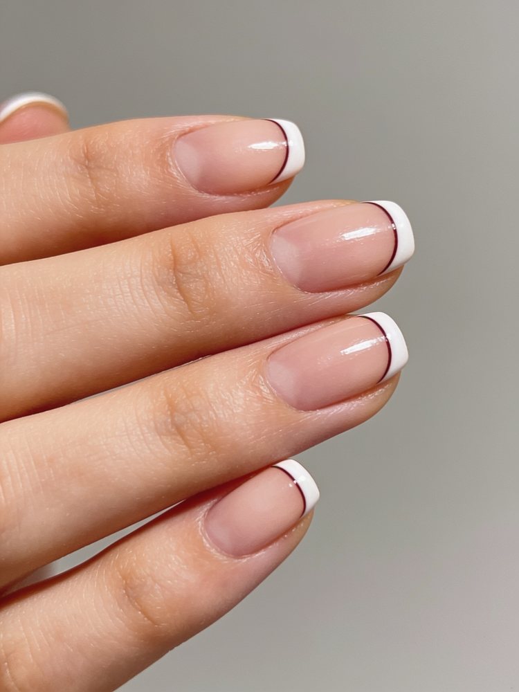 Short squoval nails with an ultra thin white French tip